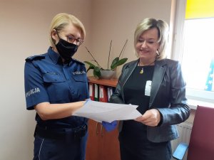 Policjantka przekazuje ulotki w urzędzie gminy