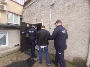 Policjanci prowadzą zatrzymanego