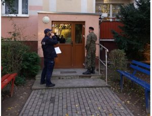 Policjant i żołnierz sprawdzają osoby przebywające na kwarantannie