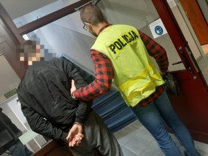 Policjant prowadzi zatrzymanego