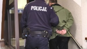 Policjant prowadzi zatrzymanego